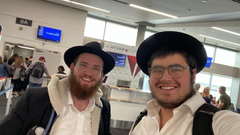 Two men wearing hats and smiling

Description automatically generated