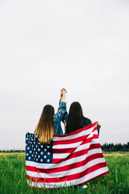 Friends holding hands with the American flag. 