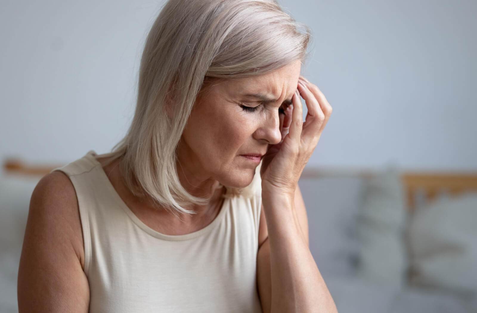 An older adult woman is experiencing sudden eye pain.d