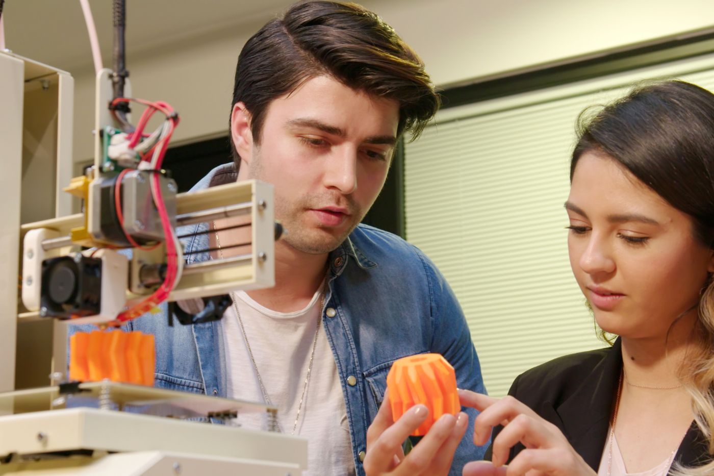 Man and woman looking at a finished 3D product