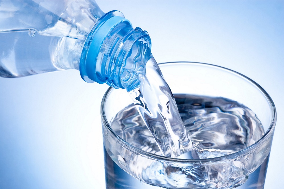 Bottle of water being poured into a glass