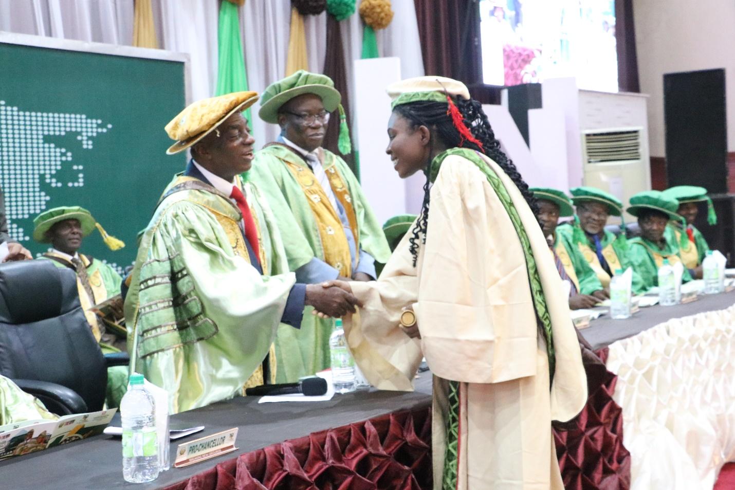 C:\Users\USER\Downloads\The Chancellor Dr David Oyedepo congratulating the overall best graduand, Danjuma in a handshake during the 10th Convocation of Landmark University.JPG