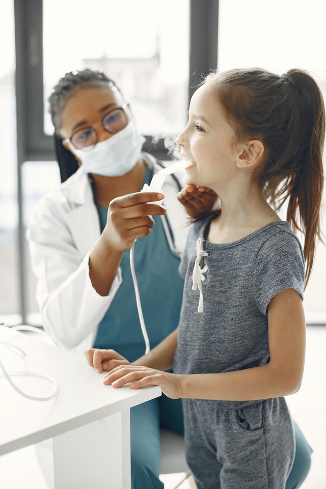 A respiratory therapist treats a young girl.