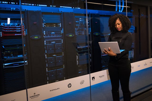 A woman standing while holding a laptop