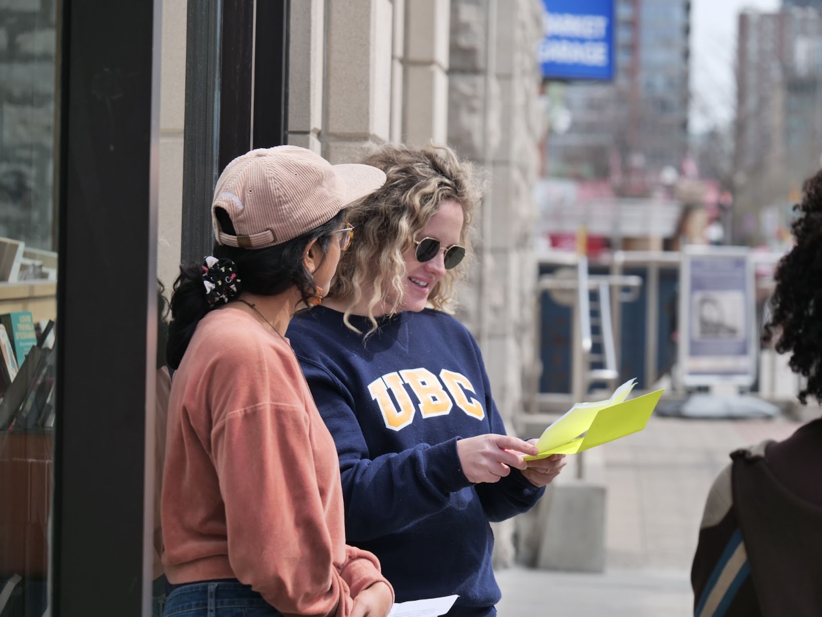 Poet Ambassadors, Manahil Bandukwala and Margo LaPierre welcome students to their next activity at Librairie du soleil bookstore. 