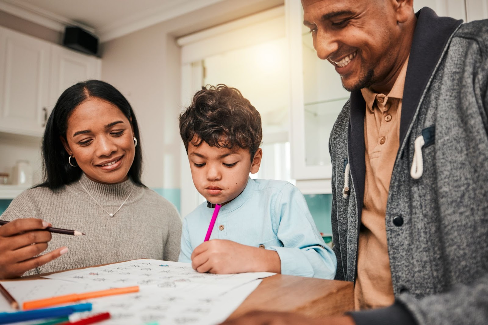 Parent helping child with writing and drawing exercises for academic readiness