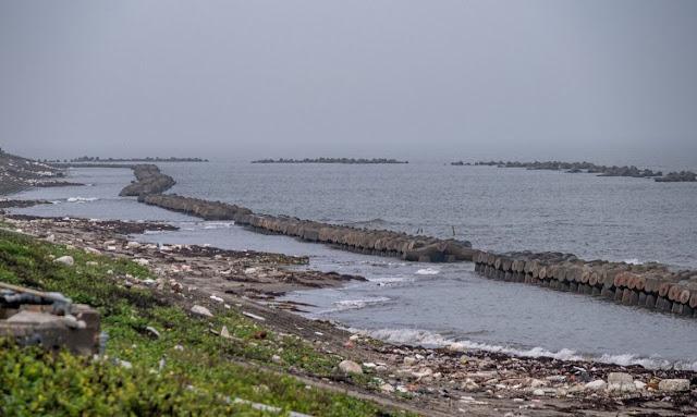 A rocky shore with a body of water

Description automatically generated