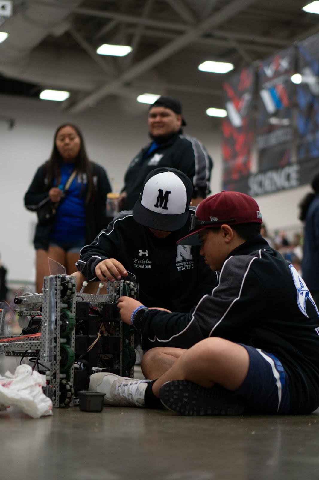 Students making adjustments to their robot. 