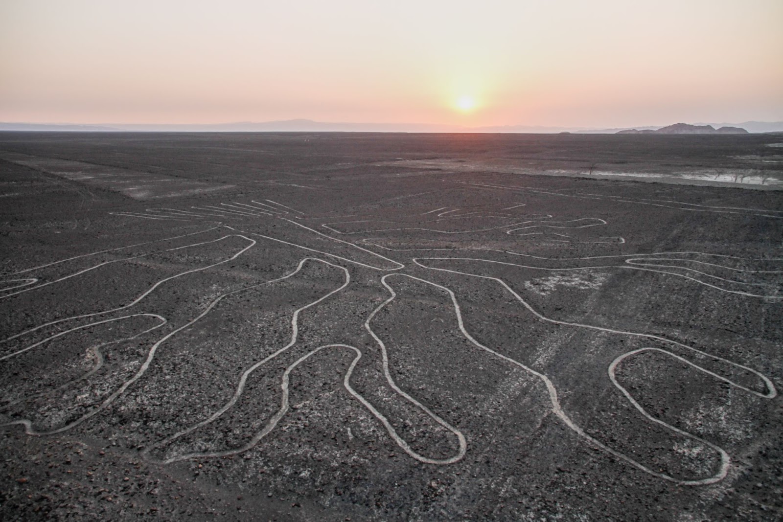 Vista de cima de uma planície em Lima, no Peru. O solo está marcado com um gigante desenho rupestre