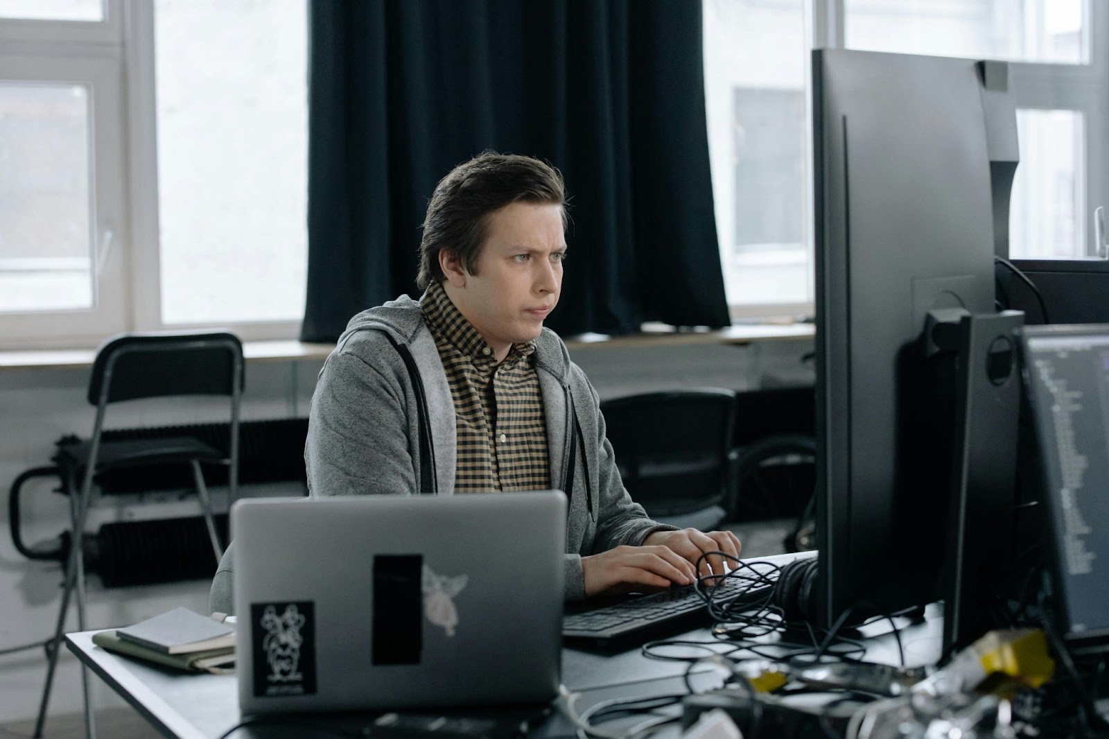 A man working with his computer doing virtual personal assistant scams