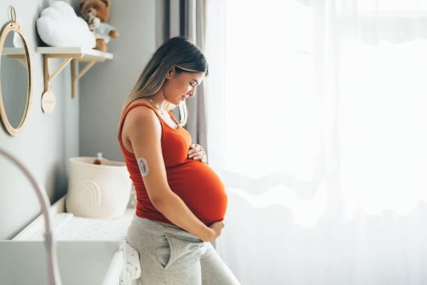 Pregnant young woman with diabetes at home feeling excited about her firstborn Young woman with diabetes enjoying the last month of her pregnancy pregnancy stock pictures, royalty-free photos & images