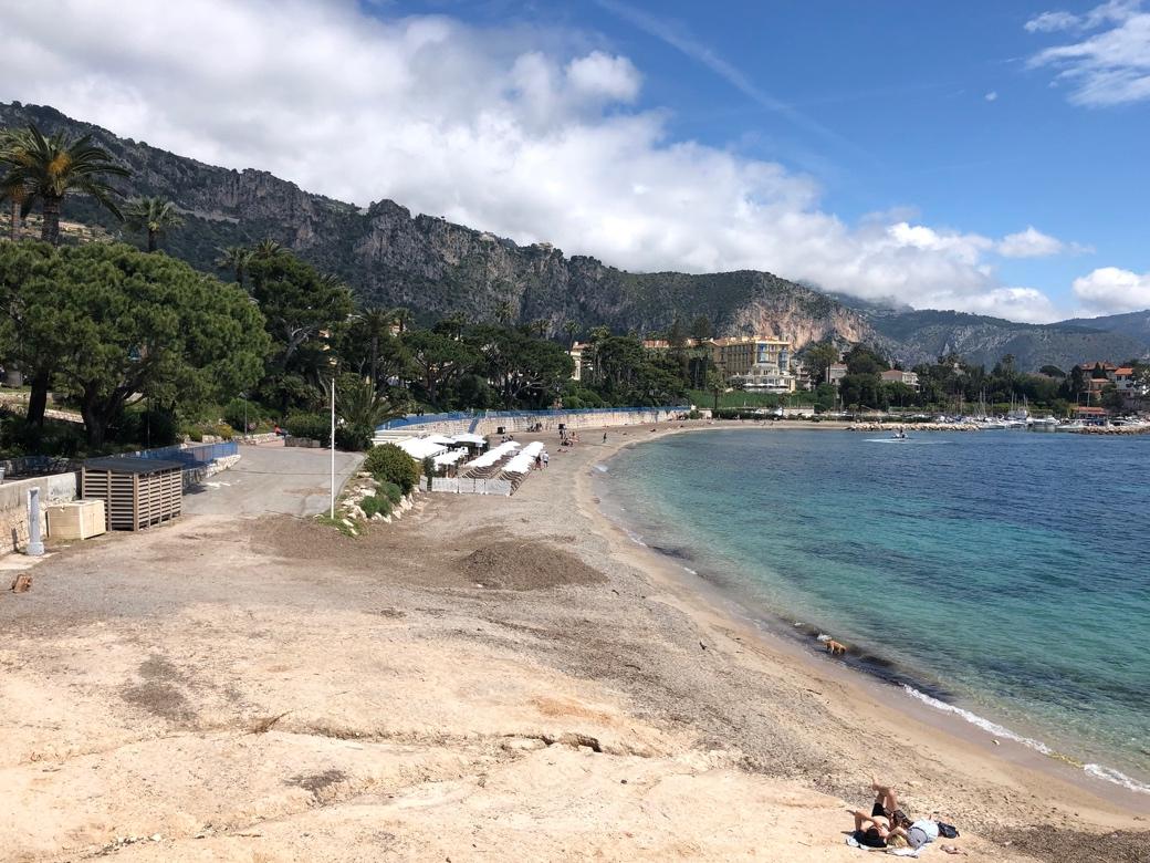 A beach with trees and mountains in the background

Description automatically generated