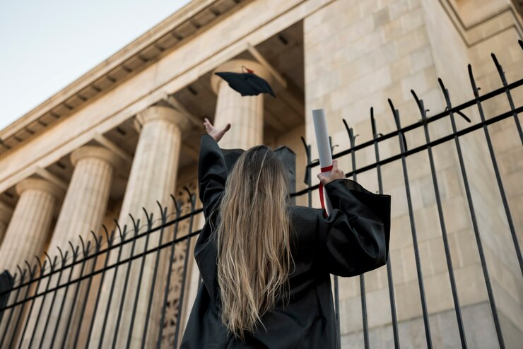 Student tossing mortarboard, celebrating graduation from psychology.