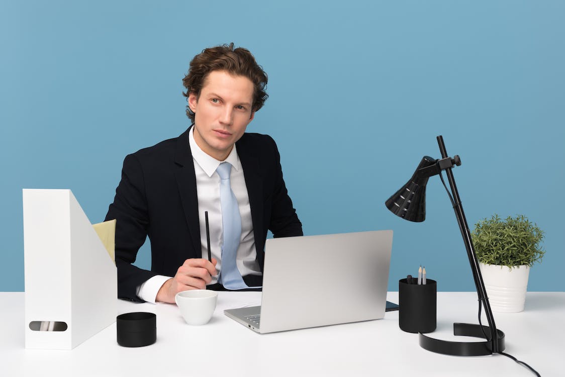 Free Man Sitting With Laptop Computer on Desk and Lamp Stock Photo