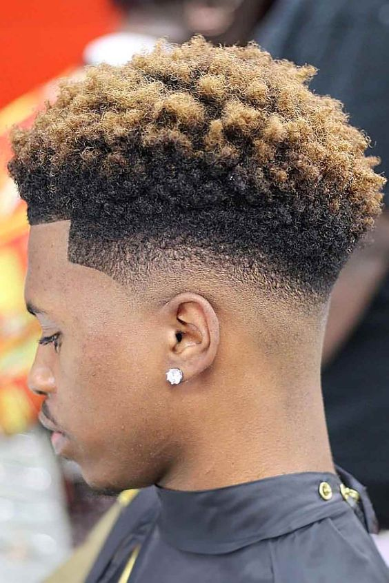 Picture showing a guy with gold colored textured hair and undercut