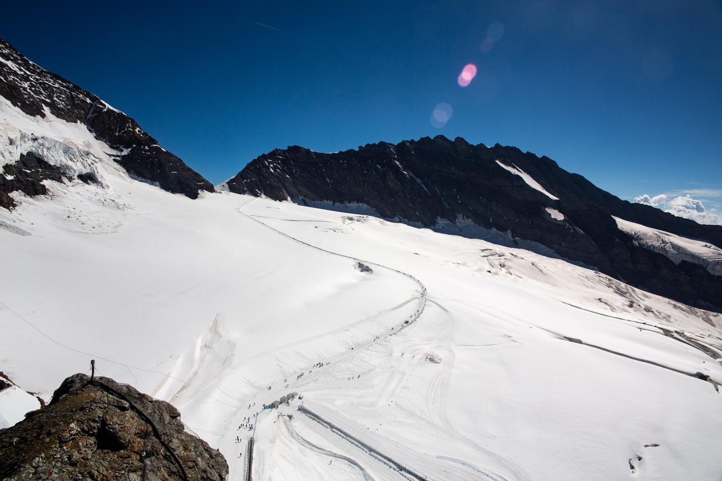 A snowy mountain with a trail

Description automatically generated