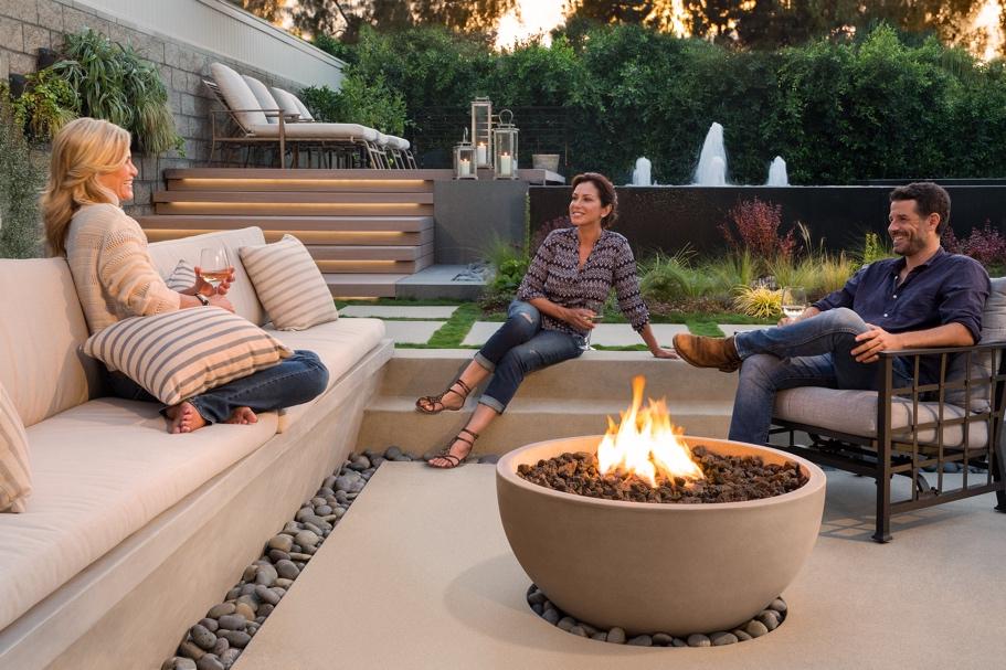 A group of people sitting around a fire pit

Description automatically generated