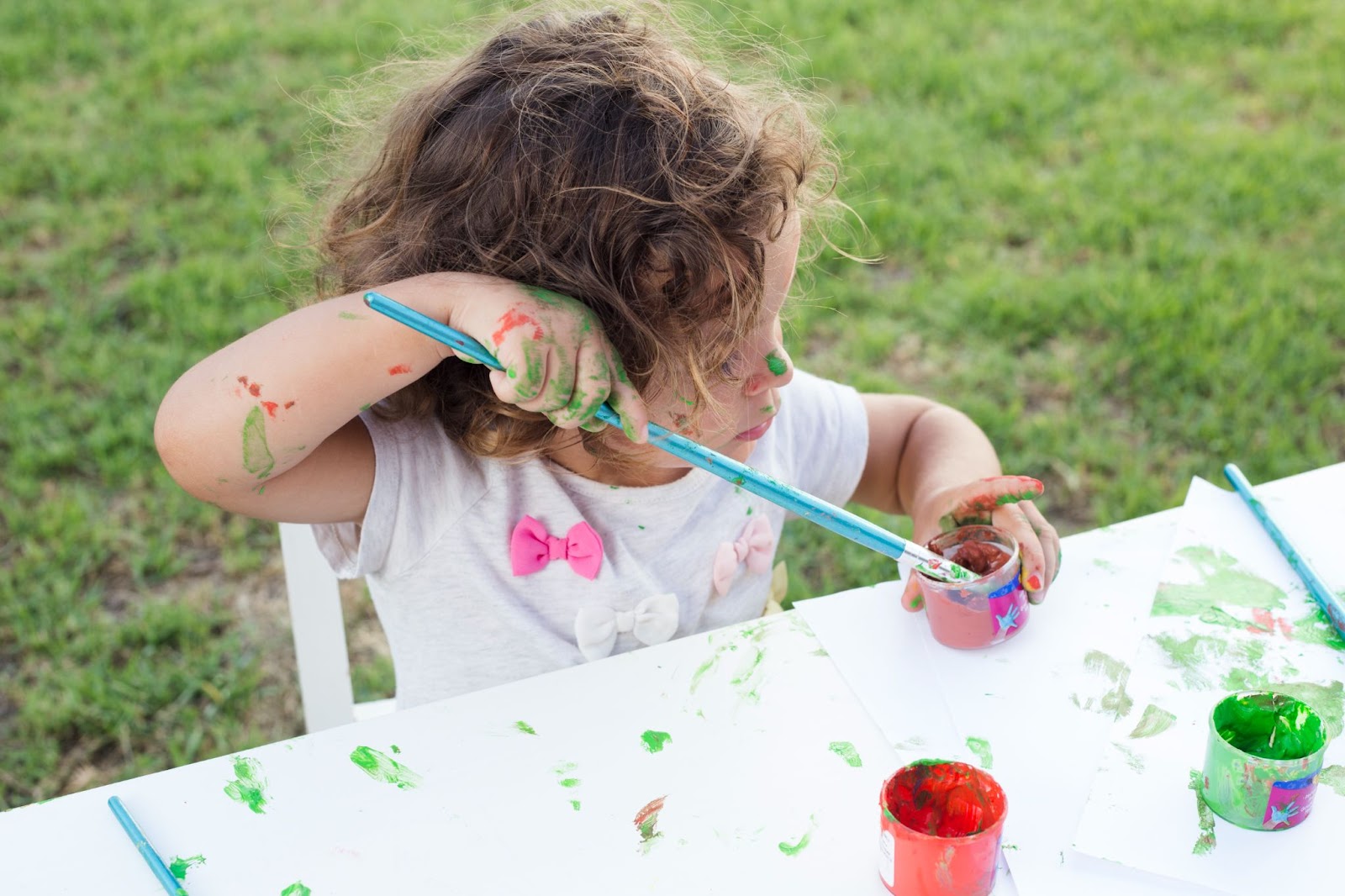 criança brincando de pintura ao ar livre