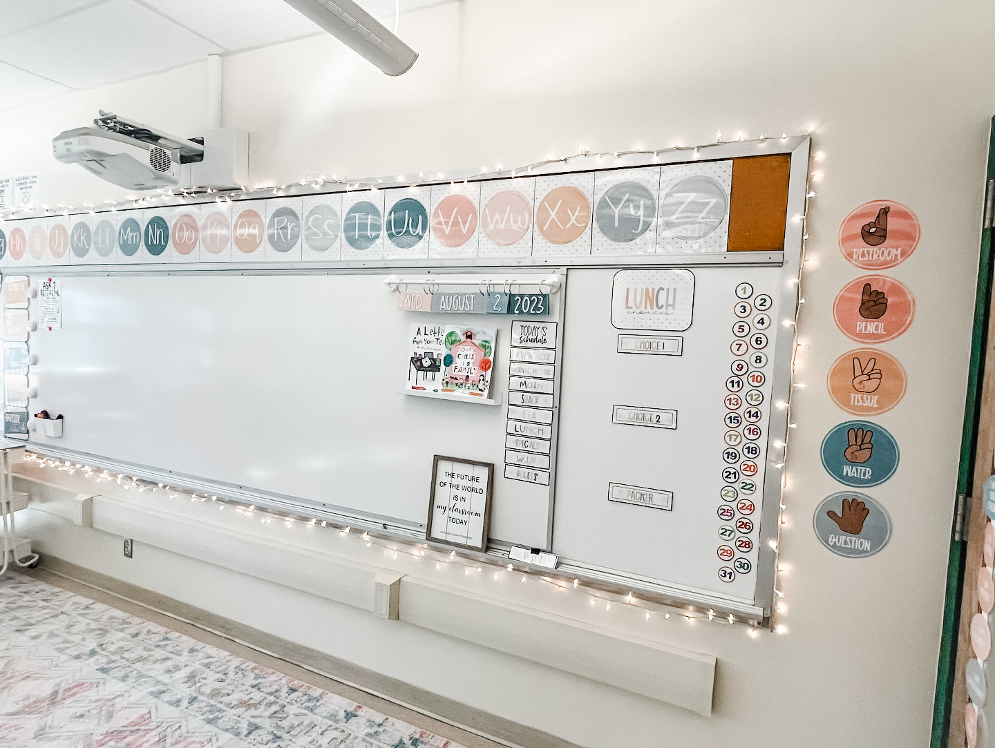 This image shows a classroom using string lights around the whiteboard at the front of the classroom for a cozy classroom effect. 