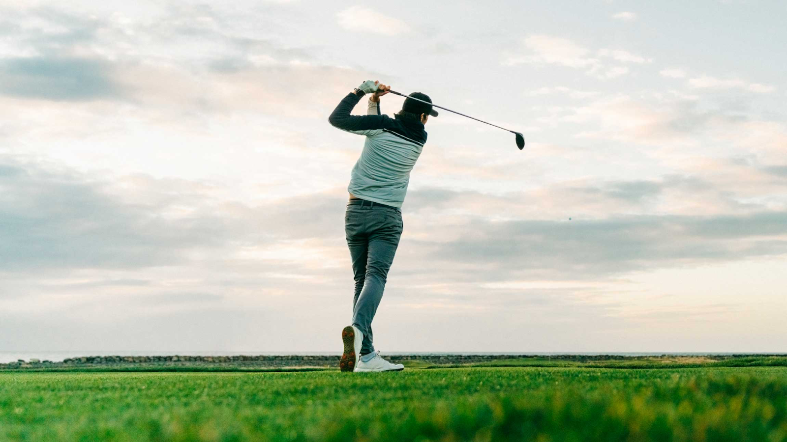 Golfer at sunset hitting ball