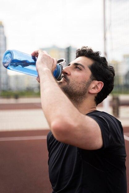 Homem bebendo água em um squeeze