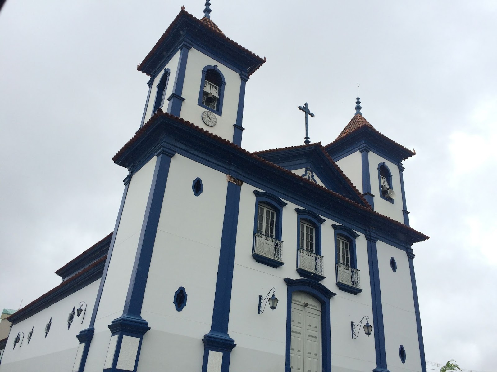 Foto da fachada da Paróquia Catedral de Santo Antônio vista de baixo para cima e levemente inclinada para a direita. Céu nublado ao fundo.