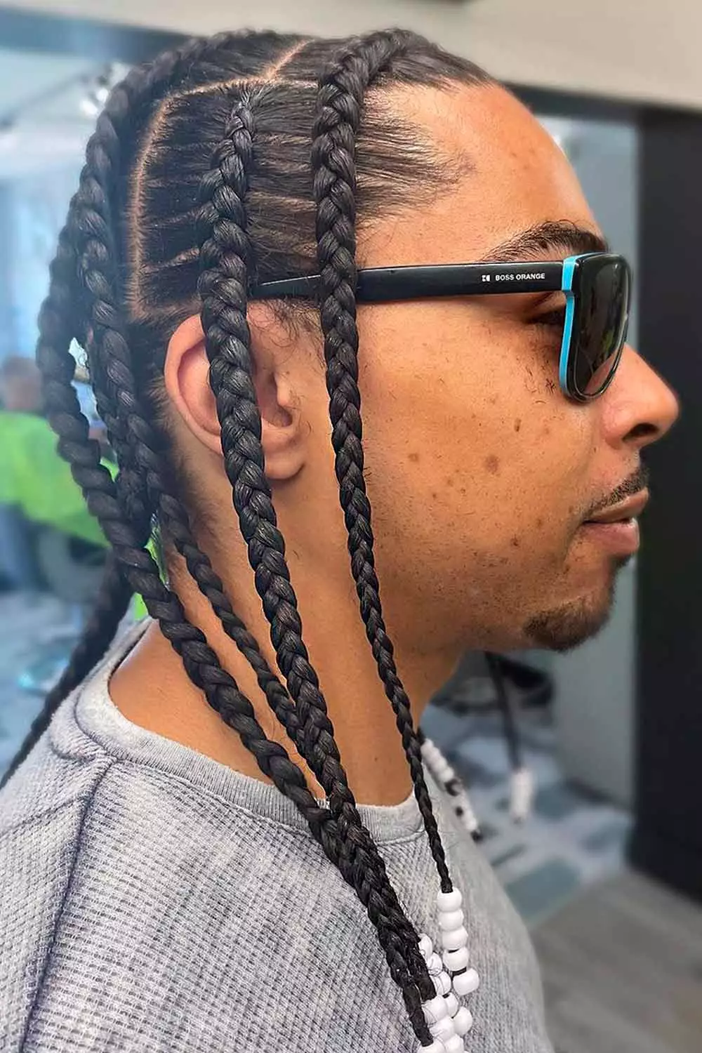 Close up view of a guy in shades rocking the pop smoke braids 