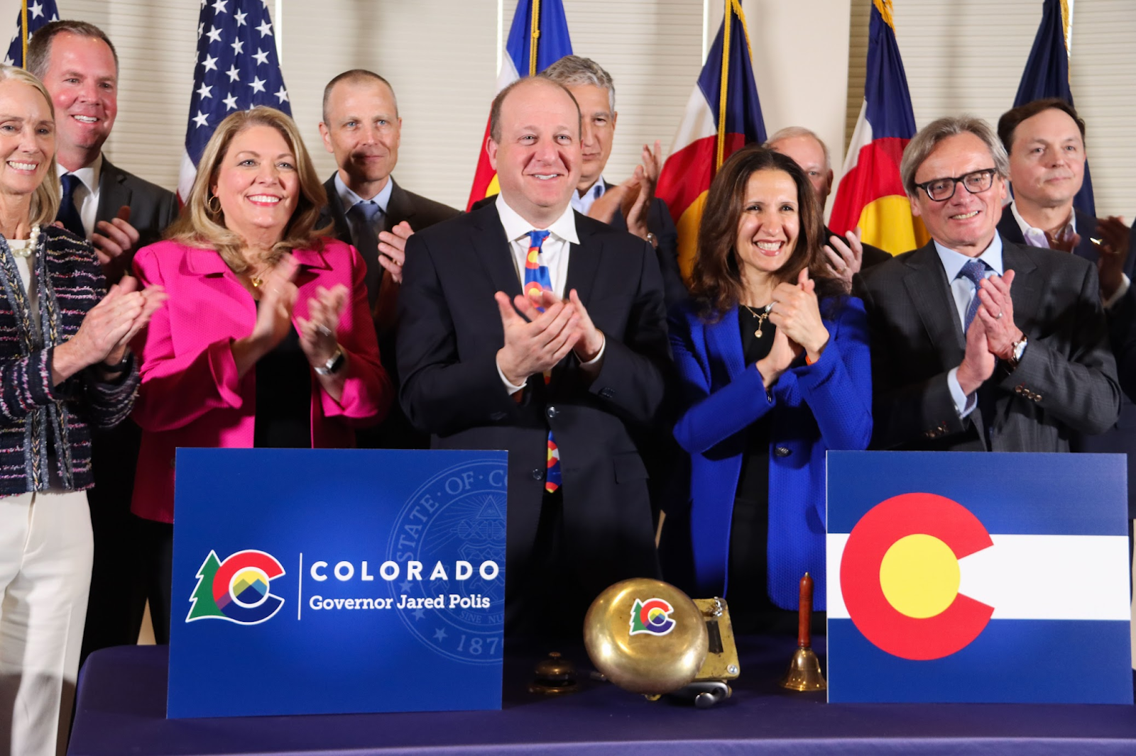 Governor Polis claps alongside New York Stock Exchange President and Colorado business leaders.