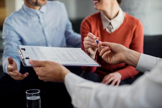 Free photo closeup of unrecognizable couple signing a contract with financial advisor