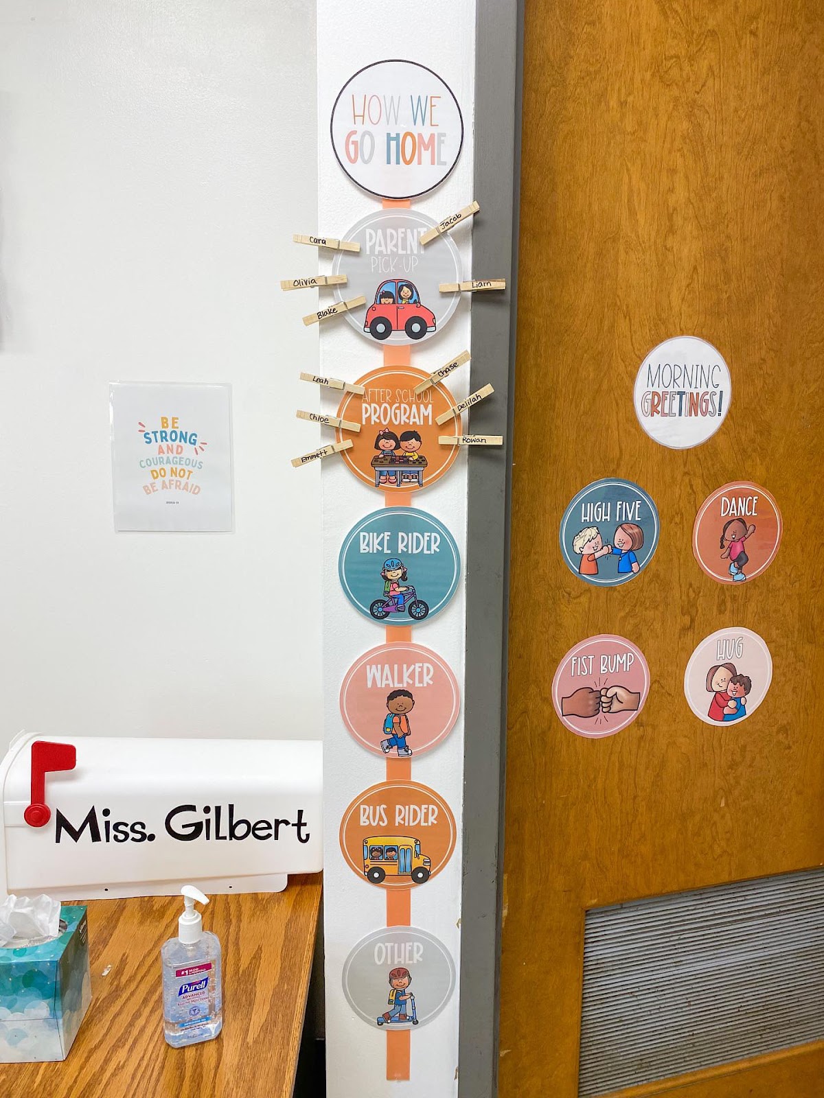 This image shows a how we go home chart displayed in a classroom. The circles are connected to a ribbon and displayed next to the door. There are clothespins around two of the circles. 