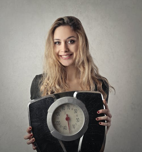 Woman Posing With Weighing Machine