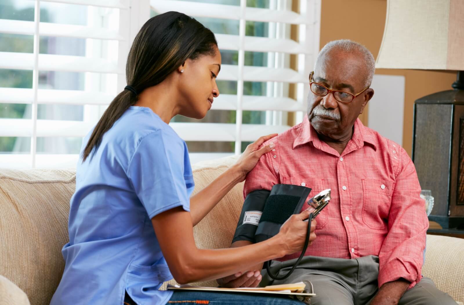 A nurse checking the blood pressure of a resident.