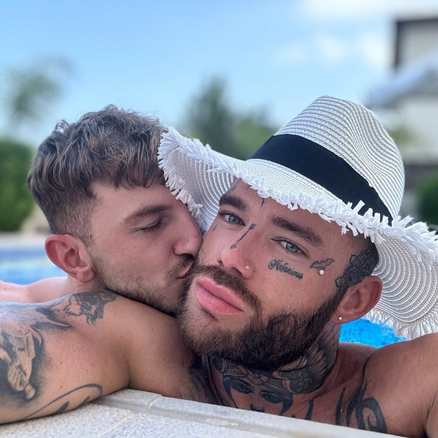 gay onlyfans content creator  Joel Hart posing in a pool in a white sun hat while getting kissed by gay muscle twunk from behind