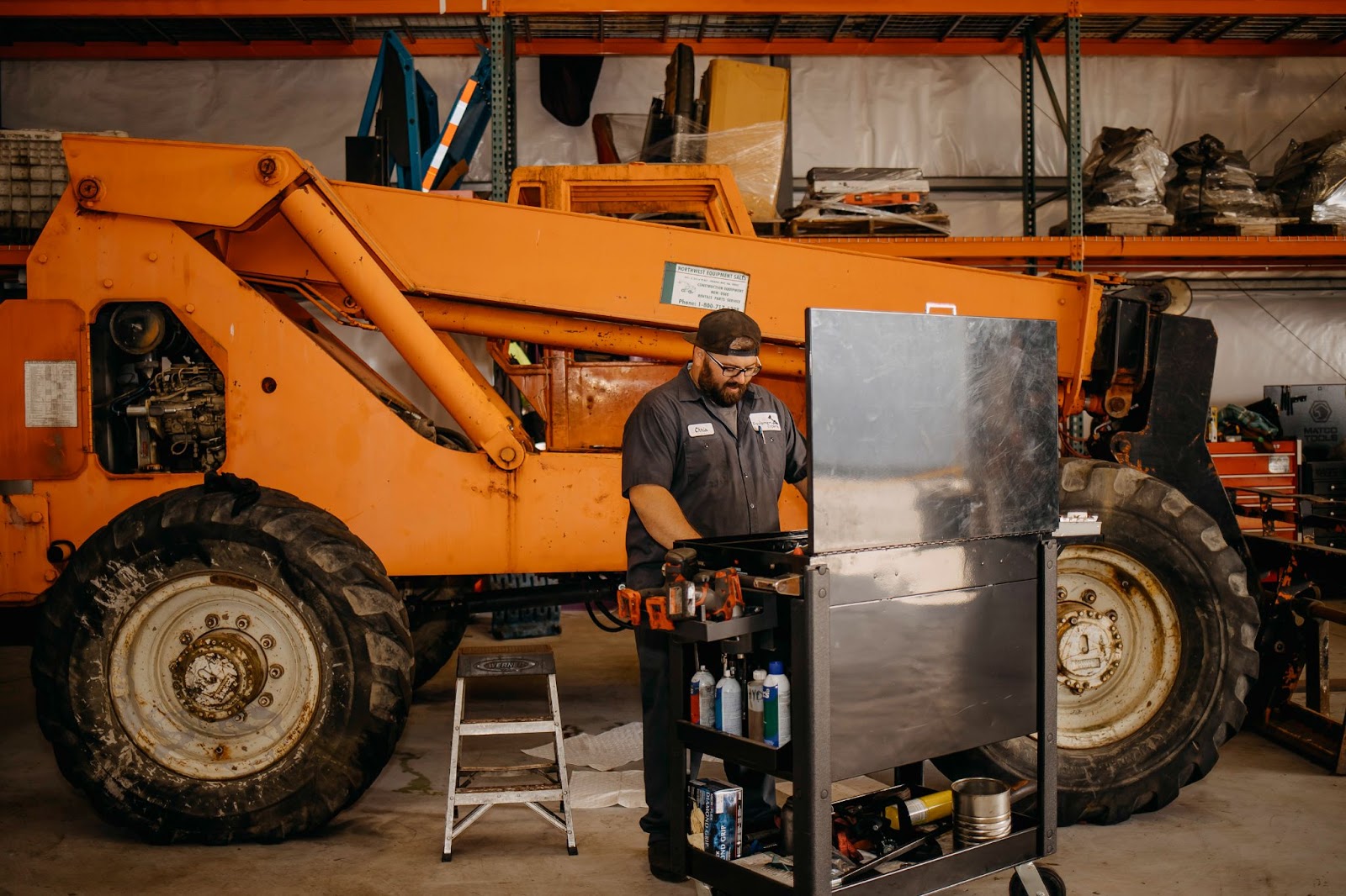 A gentleman staring at a work space with a large fleet vehicle in the background