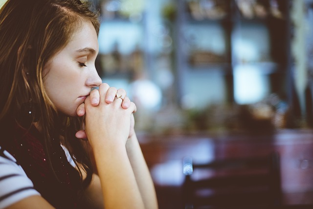 A Girl in Deep Thought With Hands Interlocked