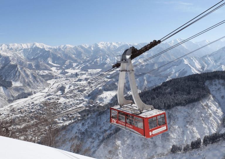 A cable car going over a snowy mountain  Description automatically generated