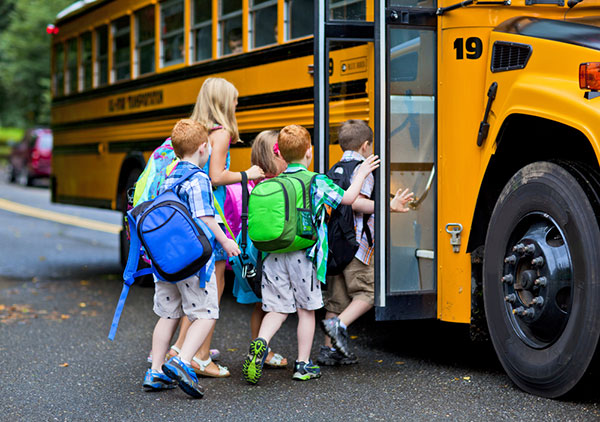 A group of children getting off a school bus

Description automatically generated