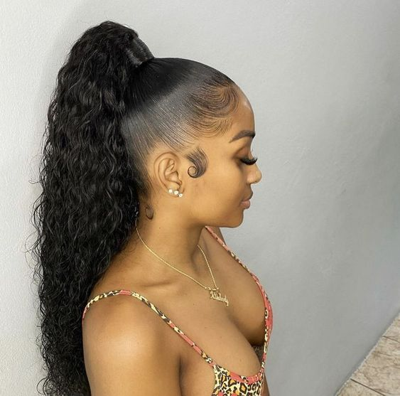 Side picture of  a lady using curls and rocking the ponytail in style