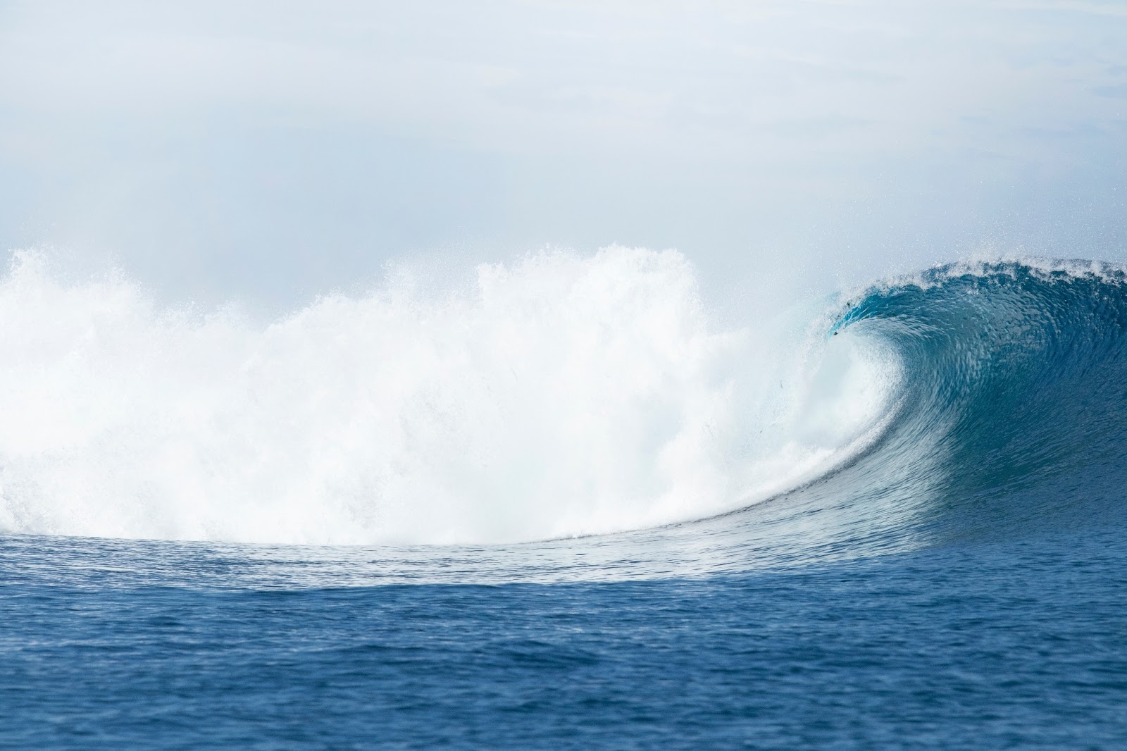A perfect surfing wave in the crystal-clear waters of the Mamanuca Islands.