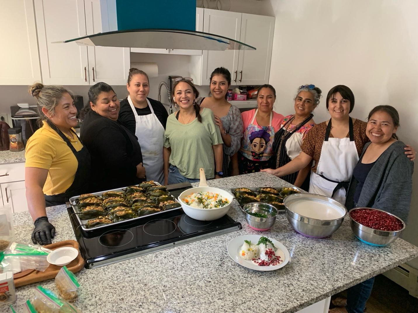 A group of women in a kitchen

Description automatically generated