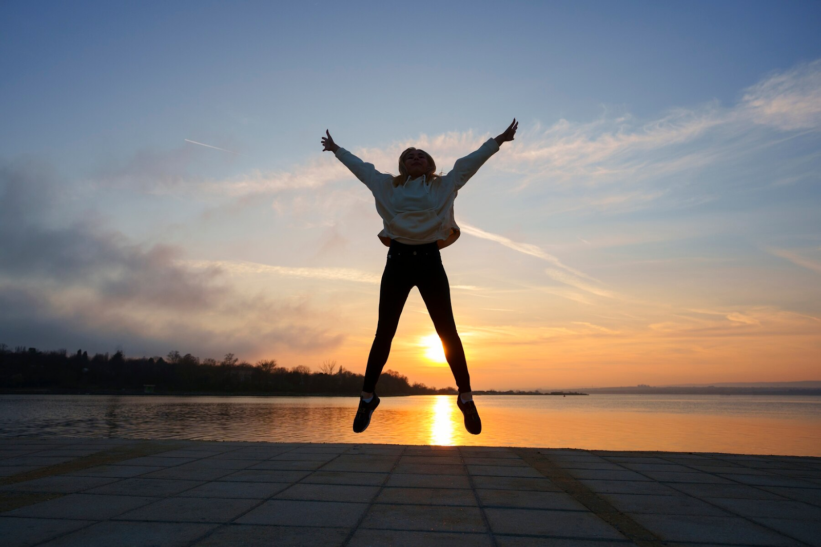 A woman jumping at sunset.