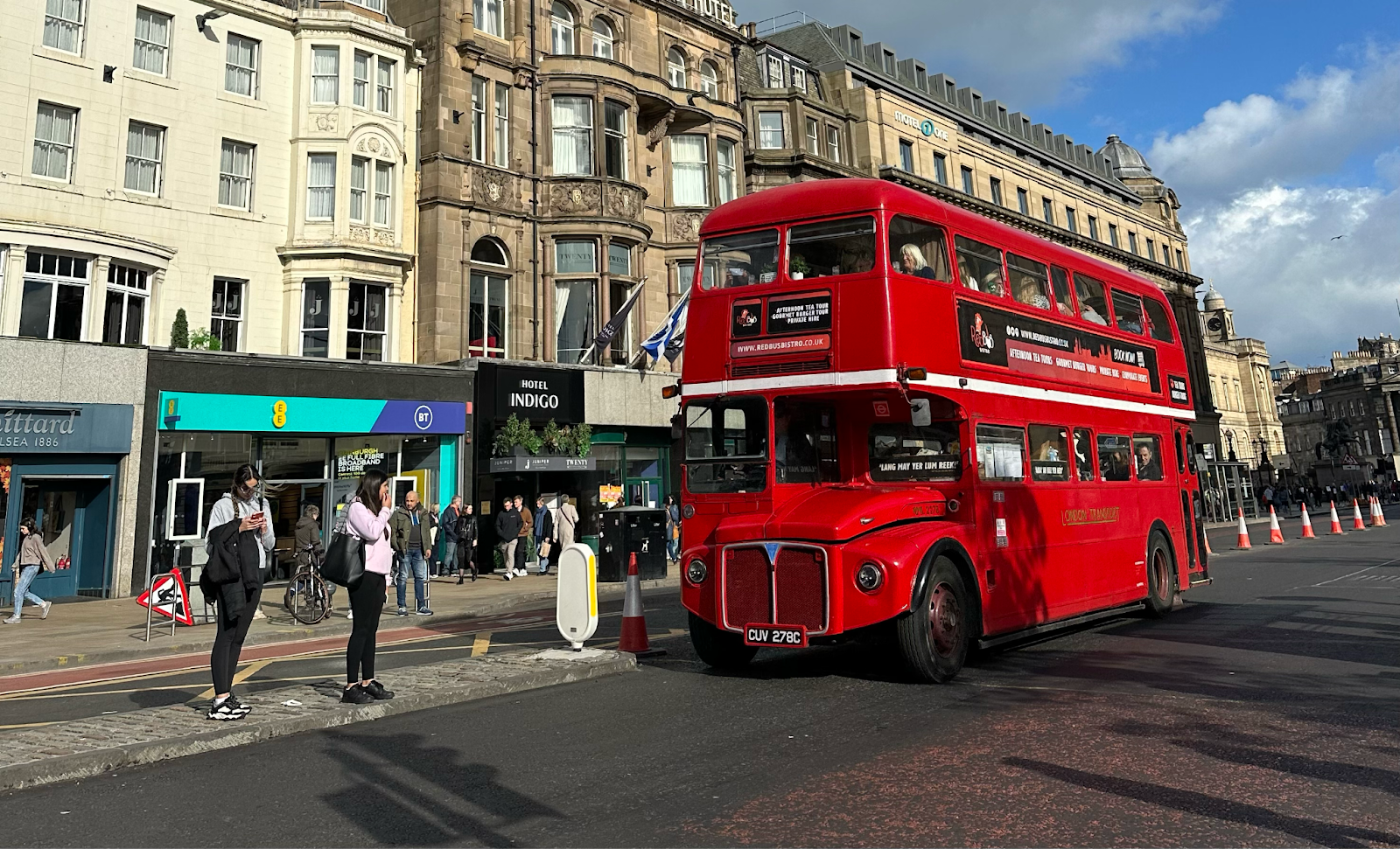 Strada a Edimburgo con negozi e autobus rosso a due piani tipico di Londra