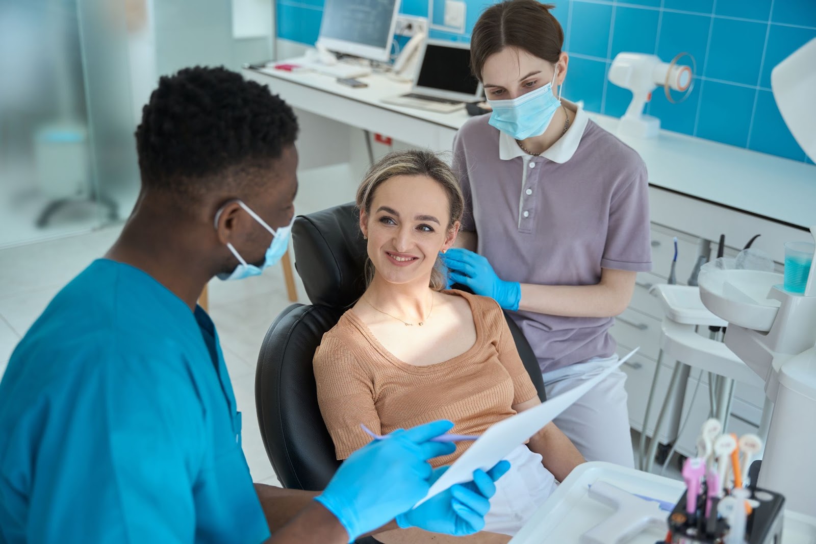 A male dentist explains dental exam results to a female patient.