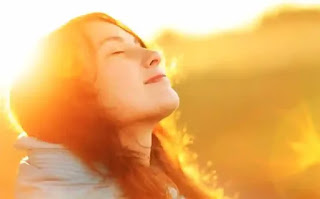 Women practicing deep breathing while gazing at the sun for improved mental health.