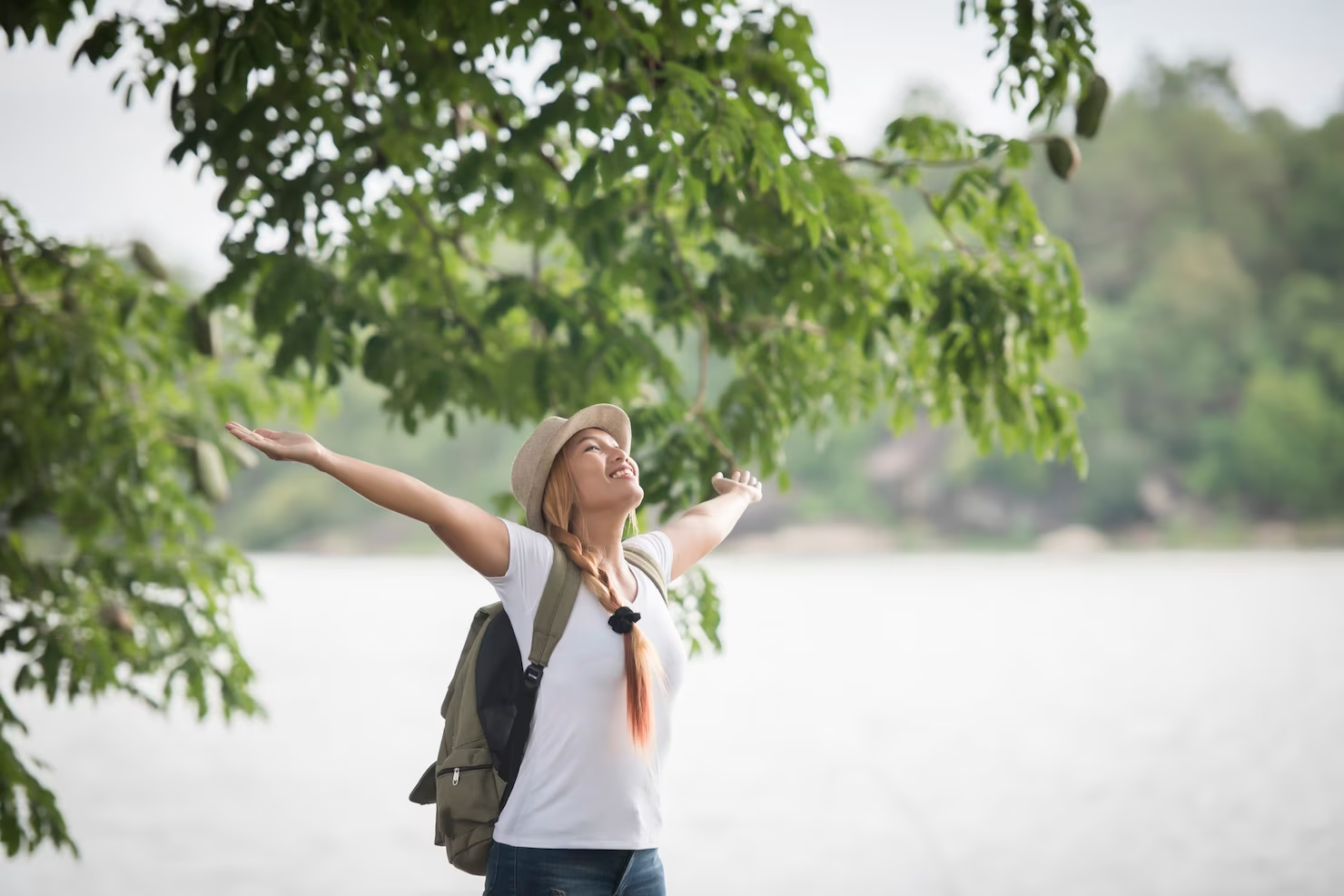 A woman enjoying nature near a river.