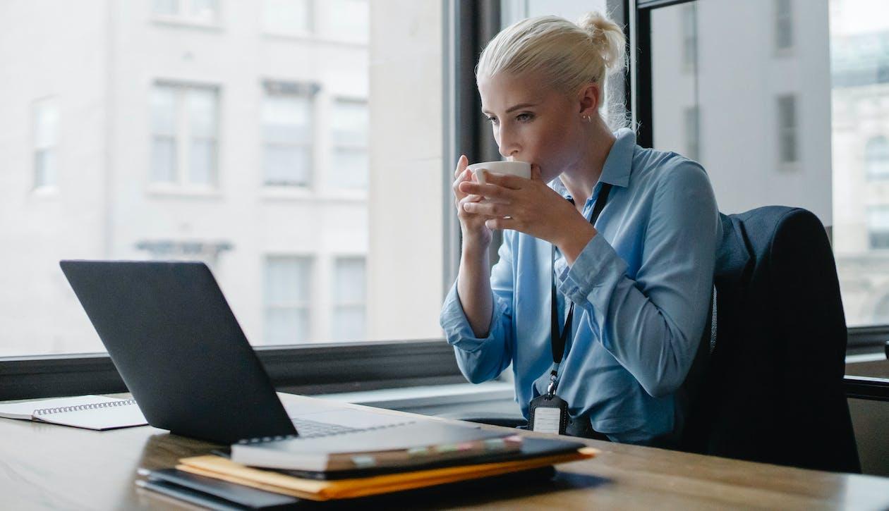 Free Female manager drinking coffee at workplace Stock Photo