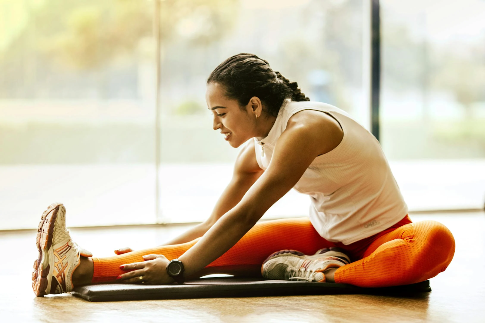A woman stretches at a gym