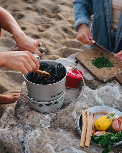 People cooking food on the beachDescription automatically generated