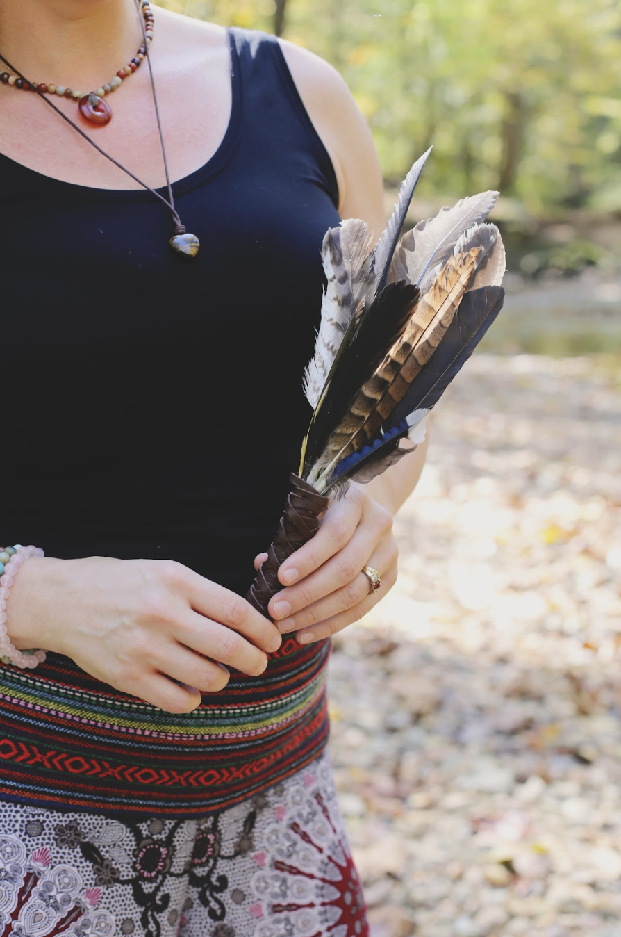 Spiritual counselor holding a feather in the forest