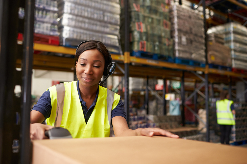 female warehouse employee scanning a barcode on a box